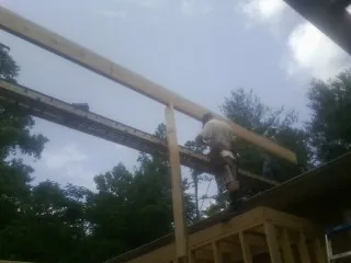 Carpenter setting a ridge beam over a new addition frame — Ice Dam Removal by Roofing Brothers in Hillsboro