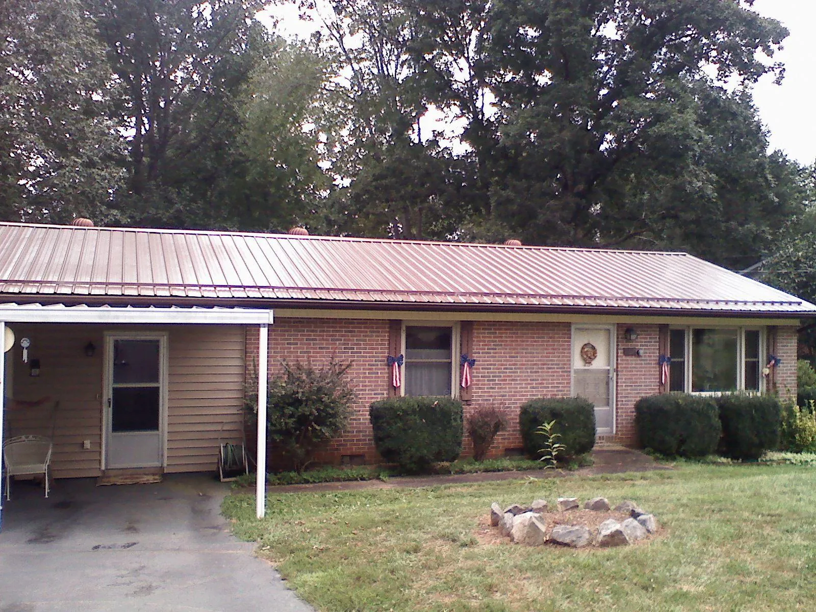 Bronze metal roof and carport on a brick ranch home — Roof Repair work by our crew in Hillsboro